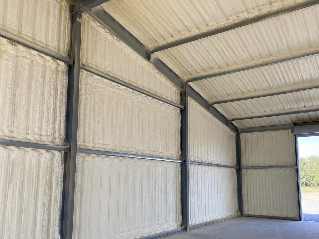 Closed-cell spray foam insulation applied to the interior of corrugated metal building panels